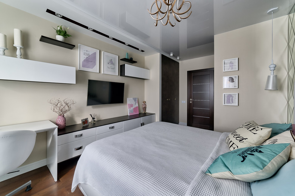 Ejemplo de dormitorio principal actual de tamaño medio con paredes beige, suelo de madera oscura y suelo marrón