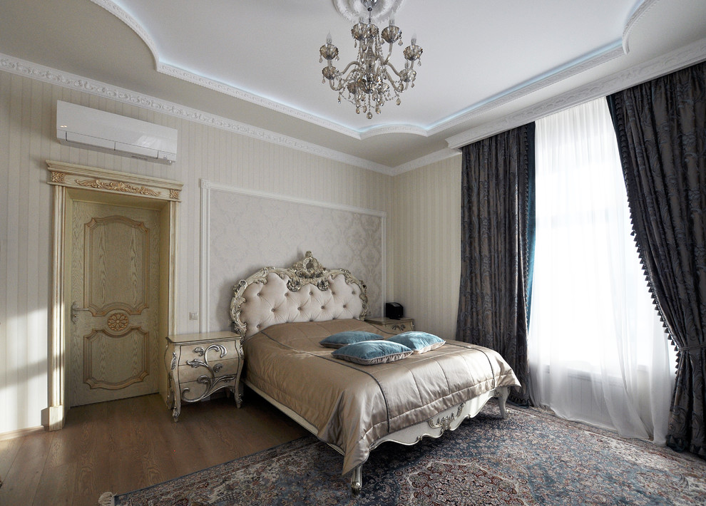 Diseño de dormitorio principal tradicional con paredes beige y suelo de madera en tonos medios