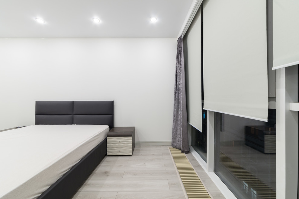 Exemple d'une grande chambre parentale tendance avec un mur blanc, sol en stratifié et un sol gris.