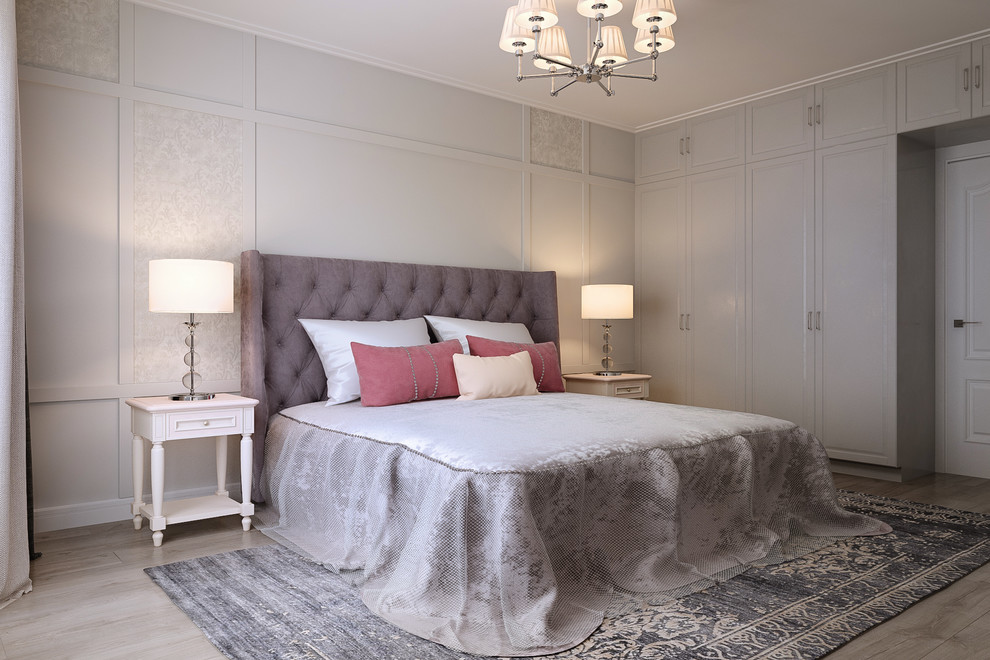 Modelo de dormitorio principal tradicional renovado de tamaño medio sin chimenea con paredes grises, suelo de madera clara y suelo gris