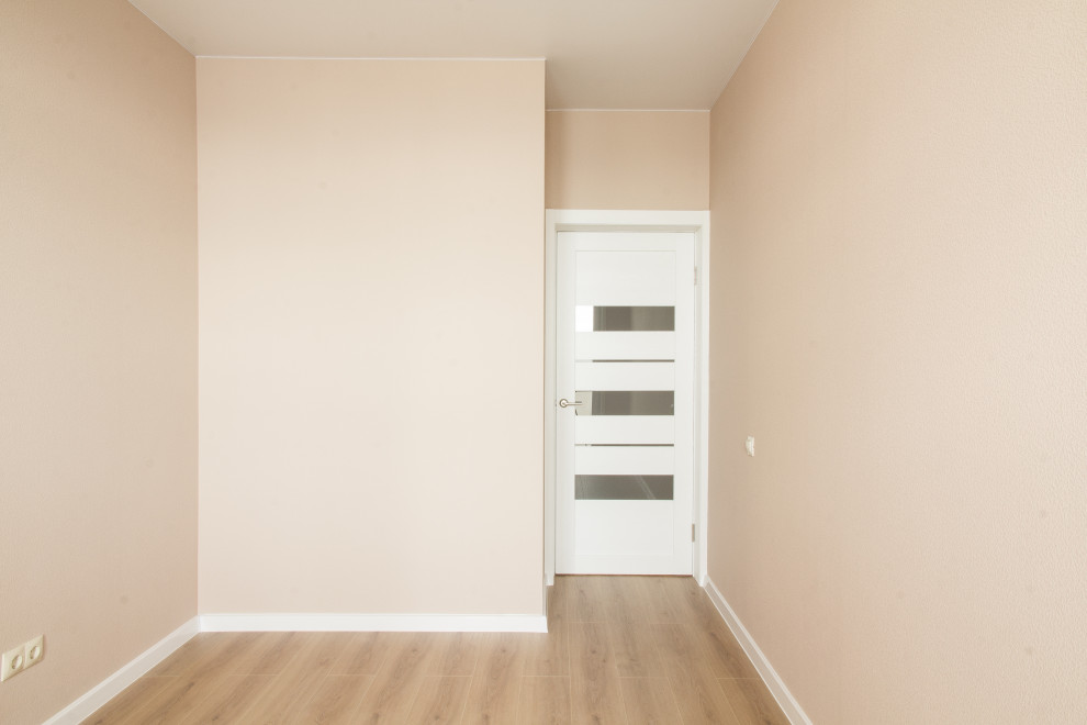 Immagine di una piccola camera matrimoniale nordica con pareti beige, pavimento in laminato e pavimento beige