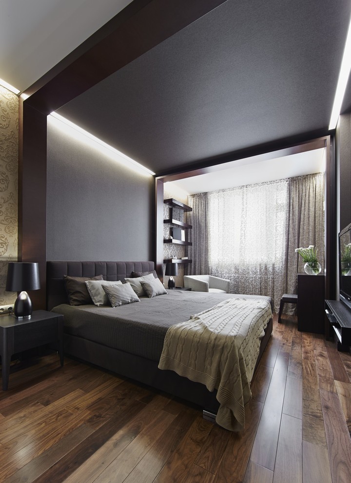 Modelo de dormitorio principal actual con suelo de madera en tonos medios