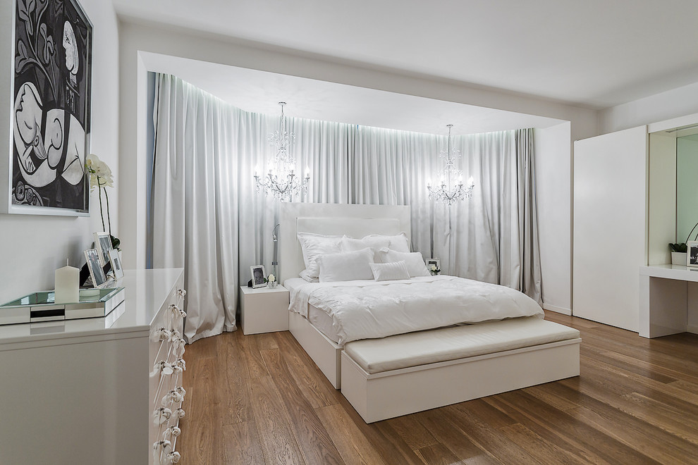 Idée de décoration pour une chambre parentale design avec un mur blanc et un sol en bois brun.