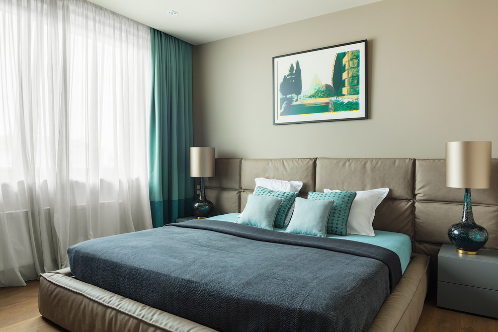 Imagen de dormitorio principal actual con paredes grises, suelo de madera en tonos medios y suelo blanco