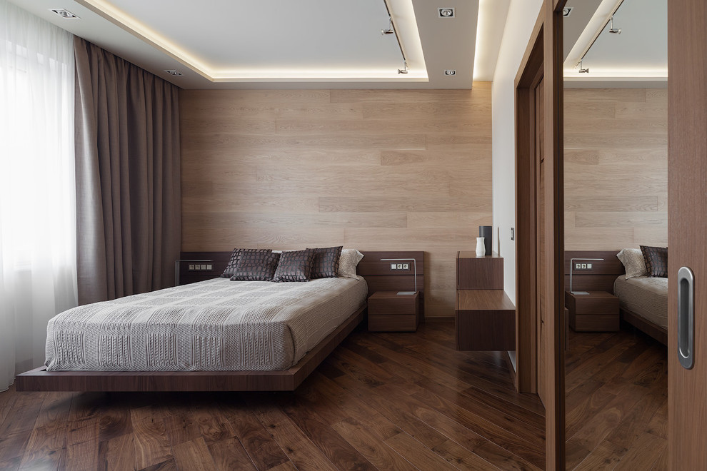 Пример оригинального дизайна: хозяйская спальня в современном стиле с темным паркетным полом и белыми стенами без камина