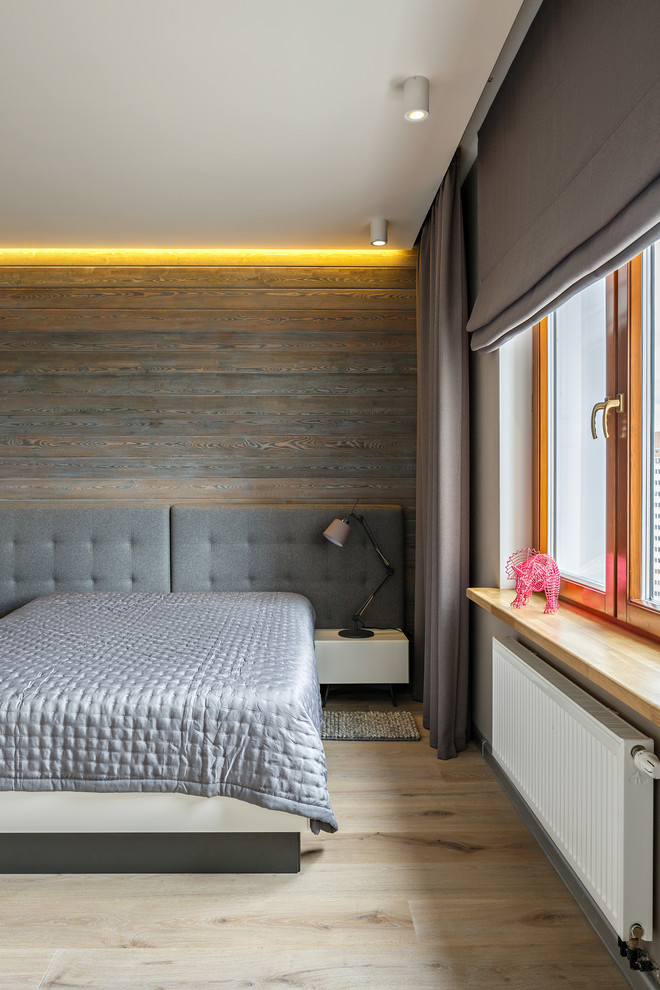 Immagine di una camera matrimoniale contemporanea con pareti grigie, parquet chiaro e pavimento beige