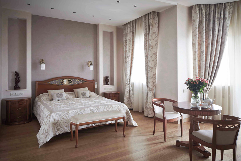 Foto di una grande camera matrimoniale chic con pareti beige, pavimento in legno massello medio e pavimento marrone