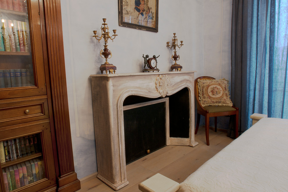 Imagen de dormitorio principal vintage de tamaño medio con suelo de madera en tonos medios, chimenea lineal, marco de chimenea de madera y suelo beige