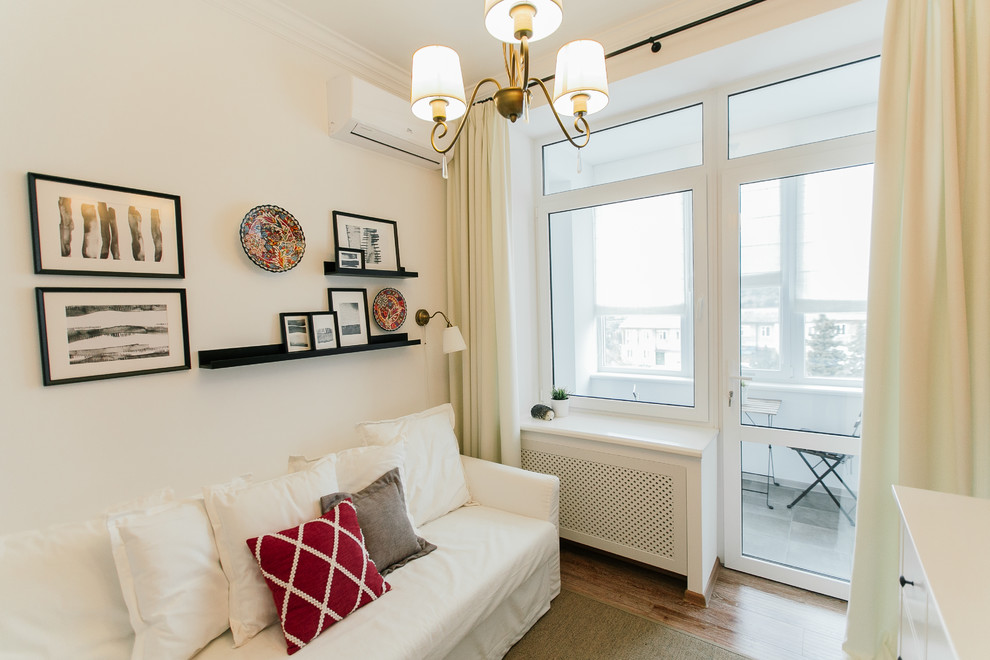 Imagen de habitación de invitados mediterránea pequeña con suelo laminado y paredes blancas