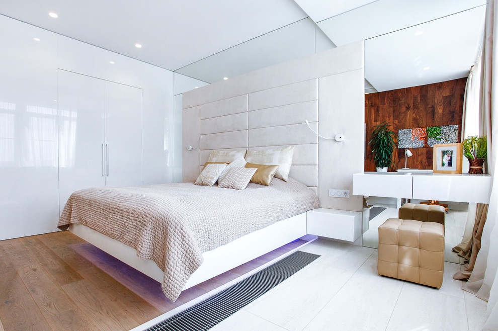Foto di una camera da letto design con pareti bianche, pavimento in legno massello medio e pavimento marrone