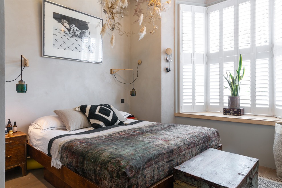 Idee per una camera da letto bohémian con pareti grigie, pavimento in legno massello medio e pavimento marrone