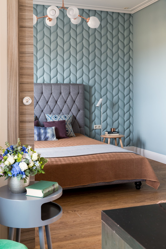 Modelo de dormitorio contemporáneo con paredes azules, suelo de madera en tonos medios y suelo marrón