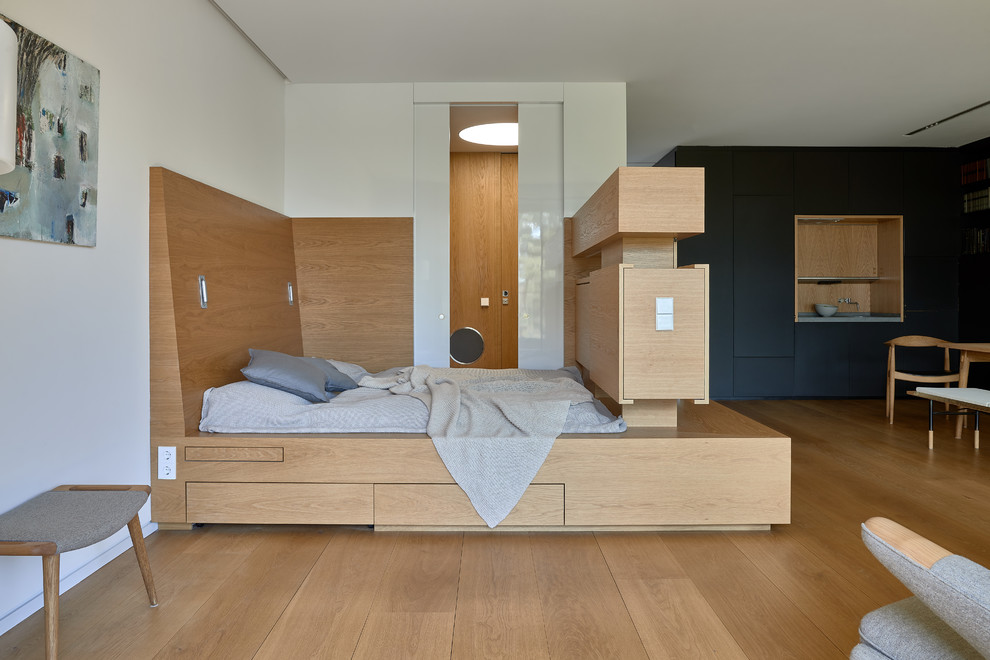 Источник вдохновения для домашнего уюта: хозяйская спальня среднего размера в современном стиле с белыми стенами, паркетным полом среднего тона, коричневым полом и кроватью в нише