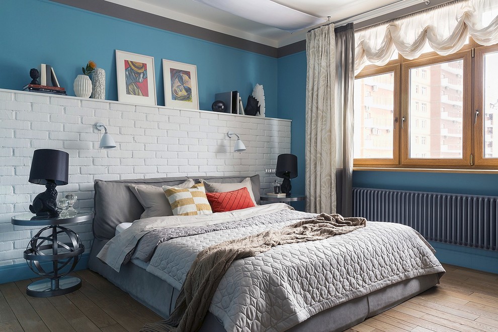 モスクワにあるおしゃれな寝室 (青い壁、無垢フローリング、茶色い床)
