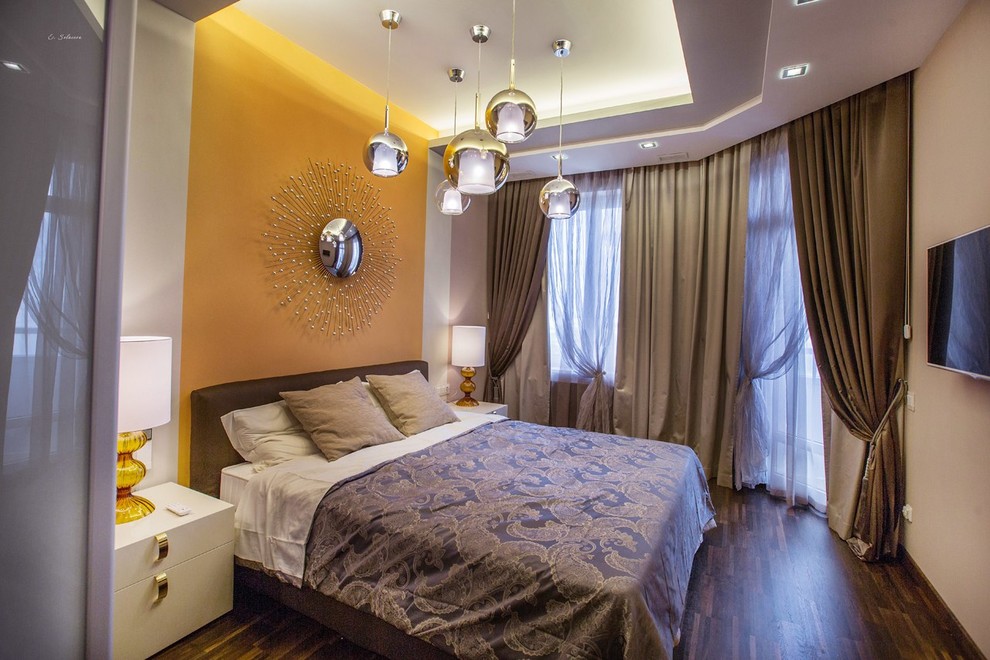 Example of a mid-sized trendy master dark wood floor and brown floor bedroom design in Moscow with orange walls