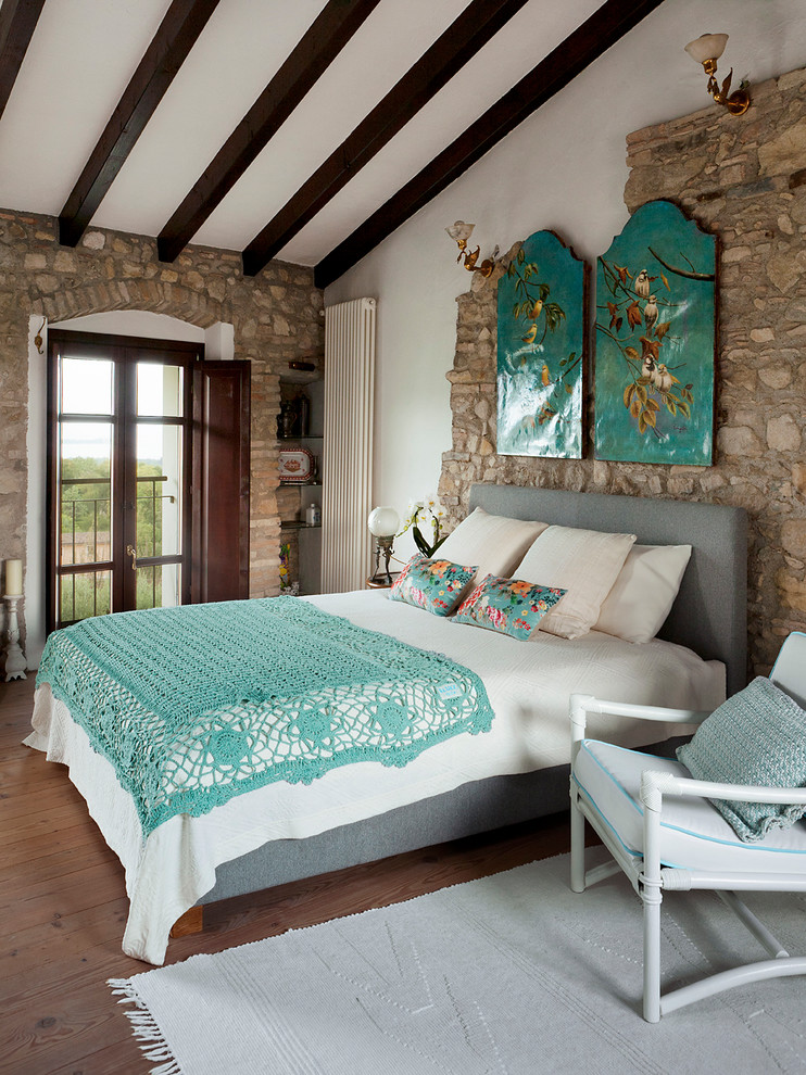 Immagine di una camera da letto country con pareti bianche, parquet scuro e pavimento marrone