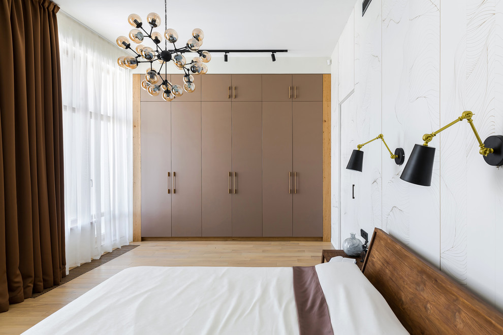 На фото: спальня: освещение в современном стиле с белыми стенами, паркетным полом среднего тона и коричневым полом