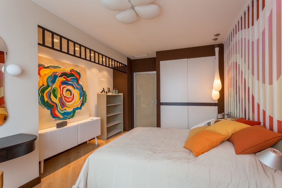 Imagen de dormitorio principal contemporáneo con paredes blancas y suelo de madera clara