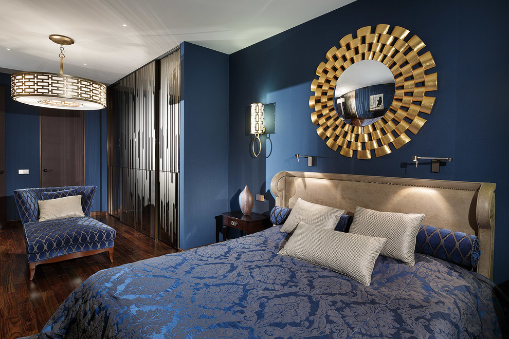 Contemporary master bedroom in London with blue walls and dark hardwood flooring.