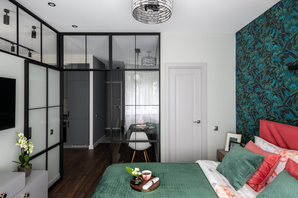 Cette photo montre une petite chambre parentale tendance avec un mur vert, sol en stratifié, un sol marron et du papier peint.