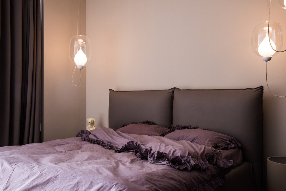 Ejemplo de dormitorio contemporáneo con paredes beige y suelo de madera en tonos medios