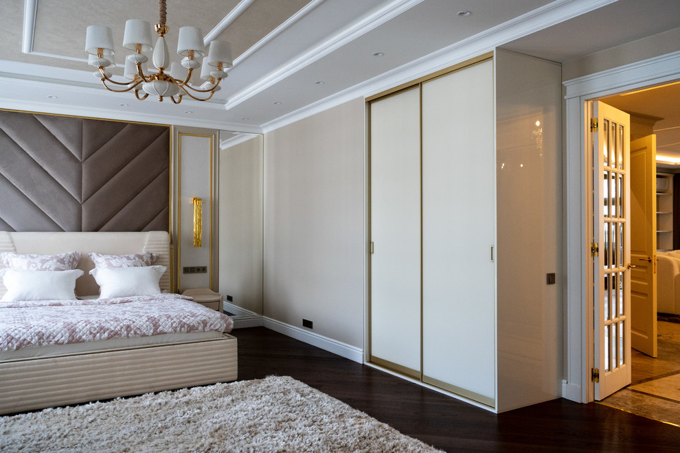 Стильный дизайн: хозяйская спальня в современном стиле с бежевыми стенами, темным паркетным полом, коричневым полом и кроватью в нише - последний тренд