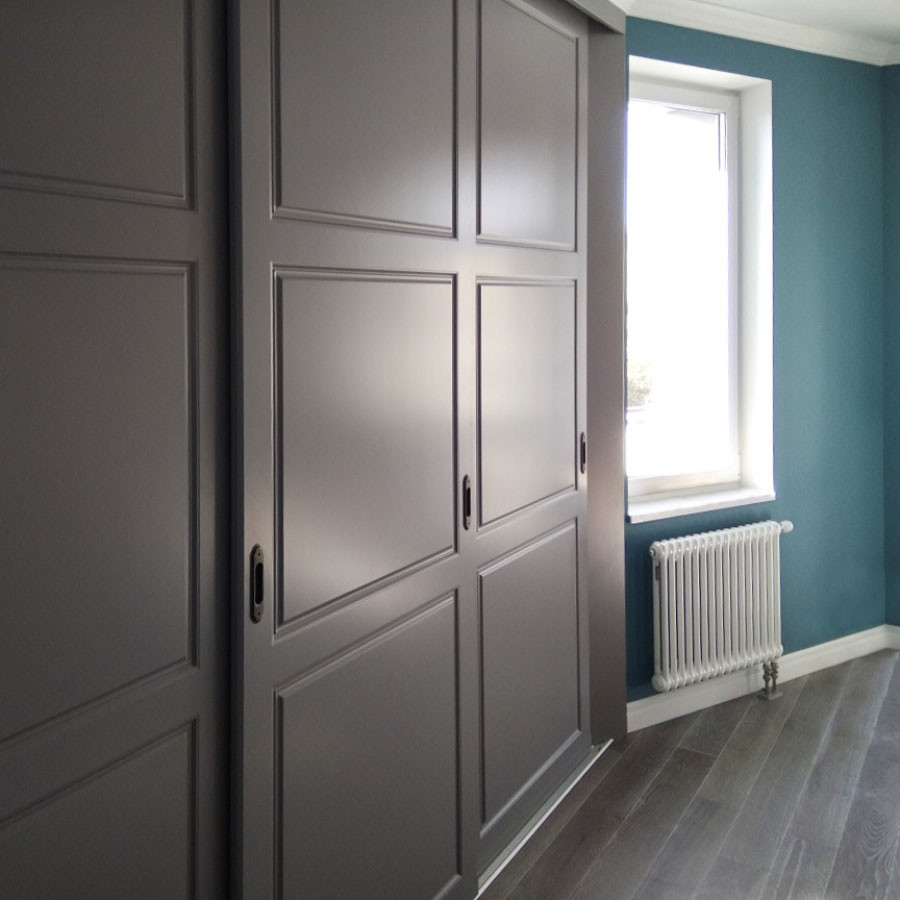 Foto de dormitorio principal tradicional renovado de tamaño medio sin chimenea con paredes azules, suelo de madera en tonos medios y suelo gris