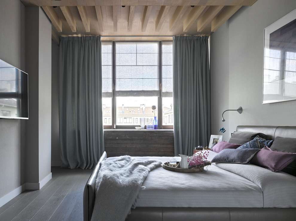 Diseño de dormitorio principal actual de tamaño medio con paredes grises, suelo de madera en tonos medios y suelo gris