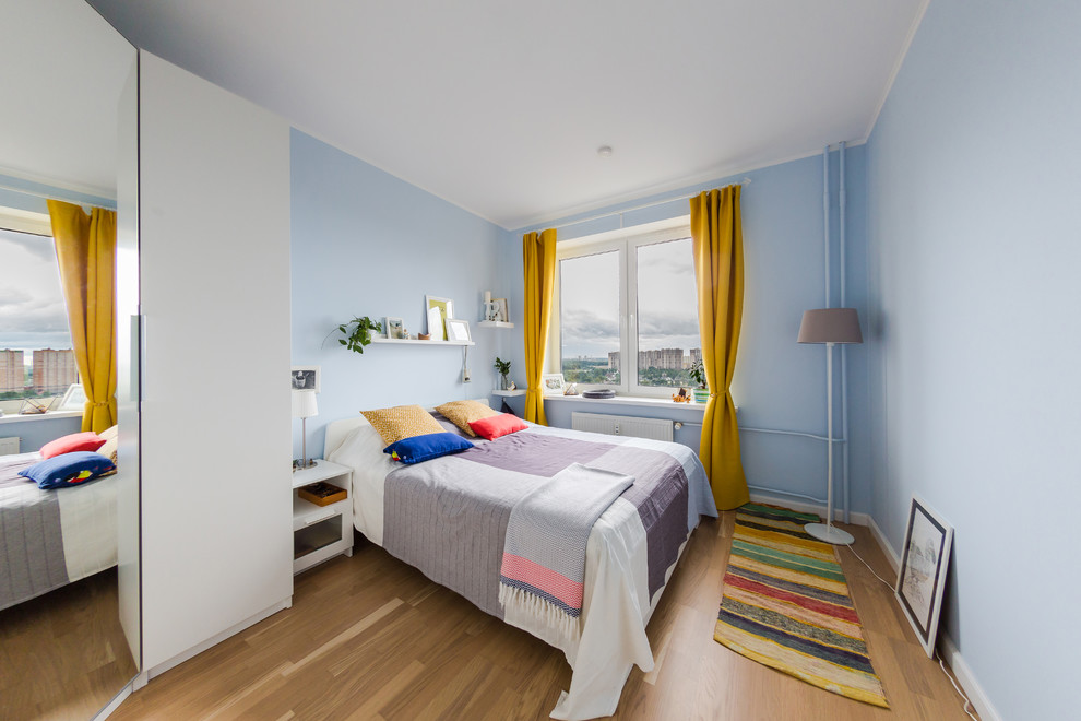 Modernes Hauptschlafzimmer mit blauer Wandfarbe, braunem Holzboden und braunem Boden in Sankt Petersburg