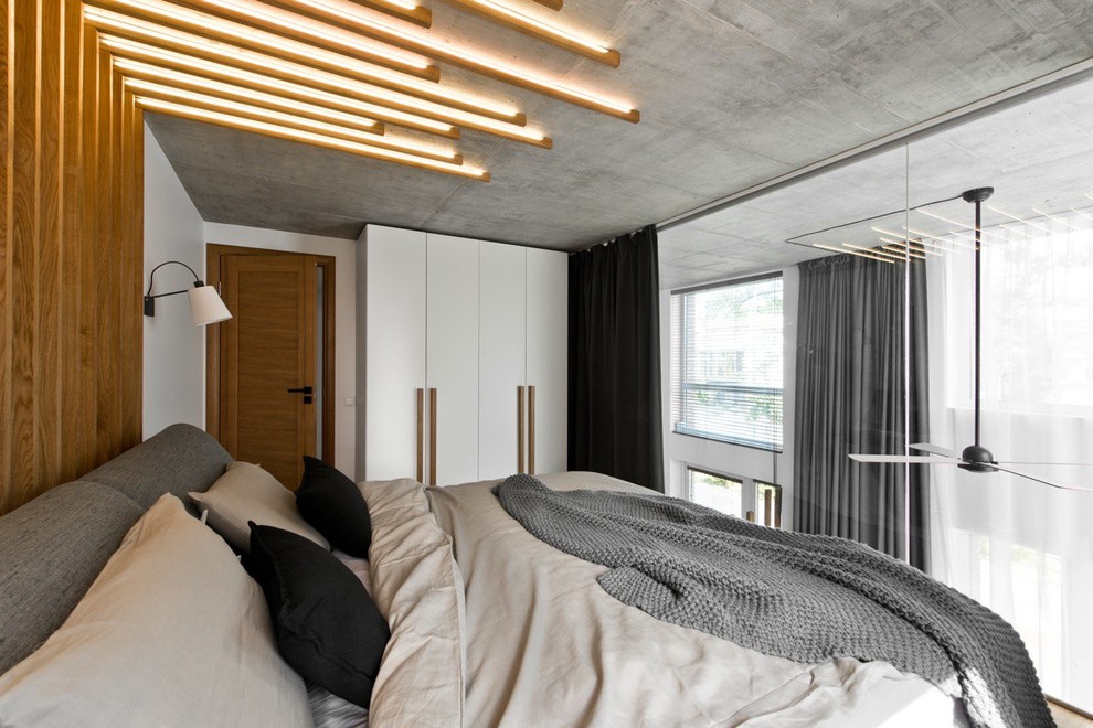 Example of an urban loft-style medium tone wood floor and brown floor bedroom design in Other with white walls