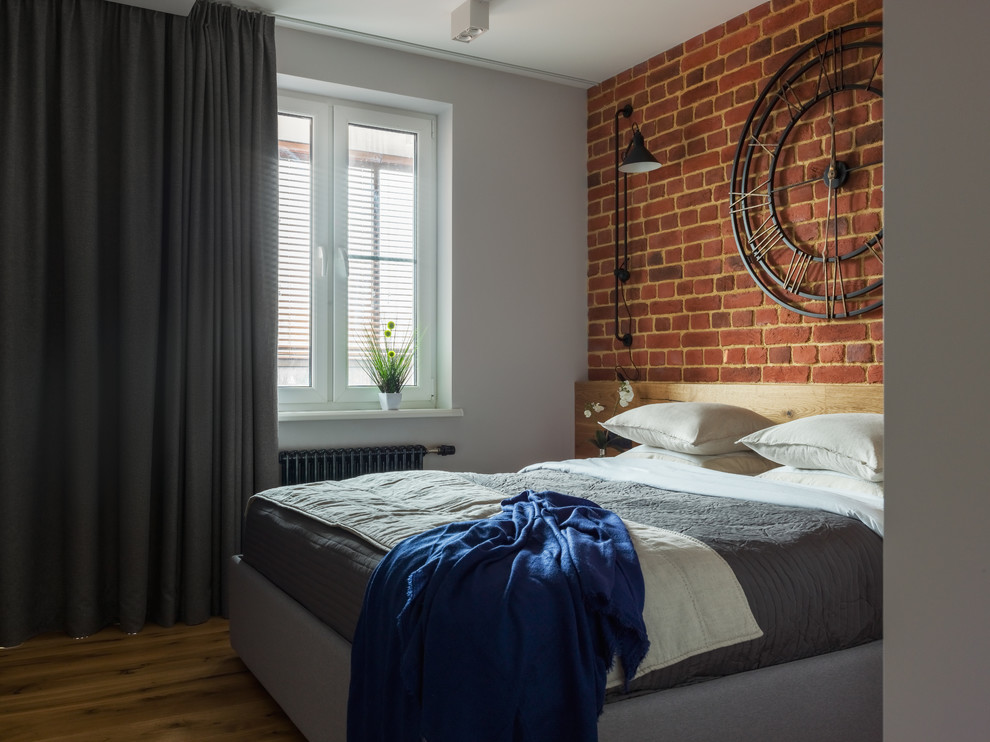 Photo of an urban master bedroom in Moscow with white walls, medium hardwood flooring and brown floors.