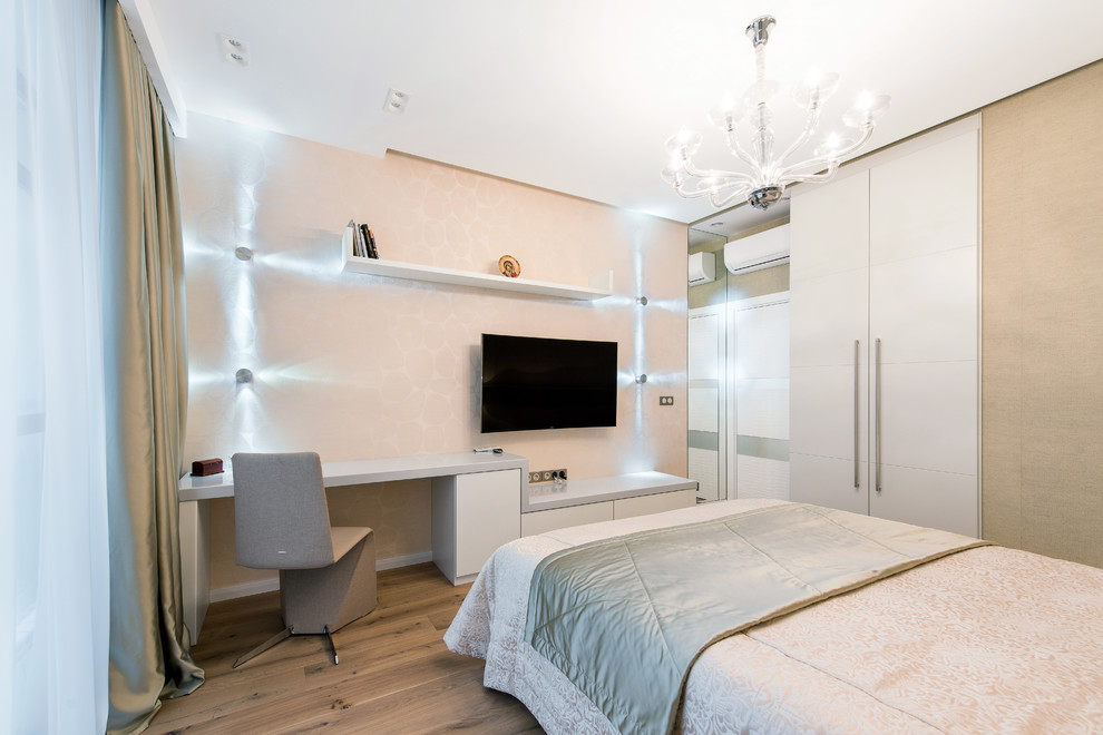Idée de décoration pour une chambre parentale design de taille moyenne avec un mur beige et un sol en bois brun.