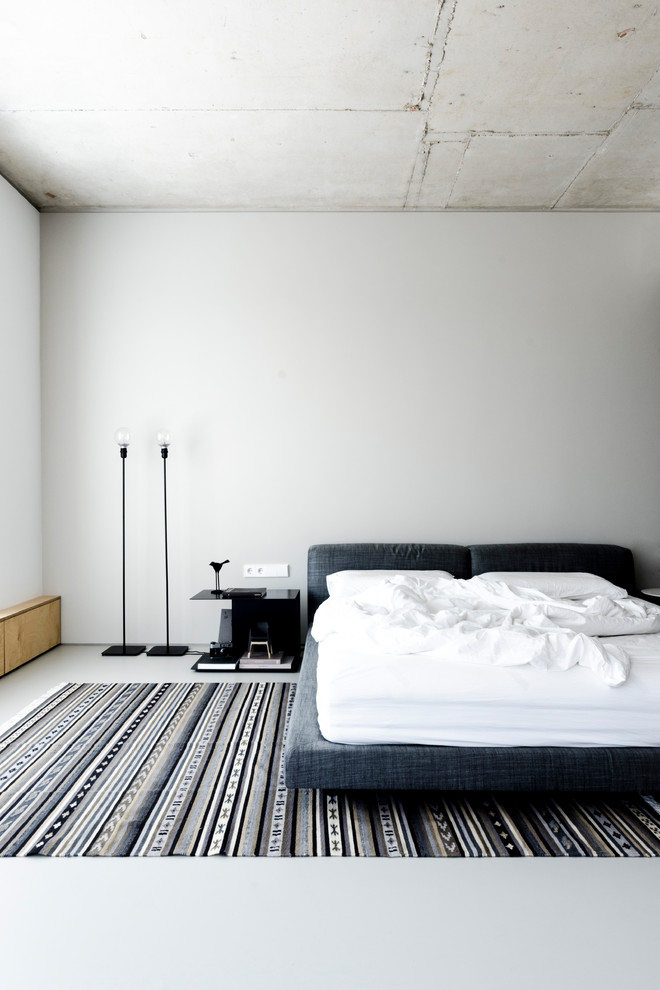 Свежая идея для дизайна: спальня в стиле лофт с белыми стенами и серым полом - отличное фото интерьера