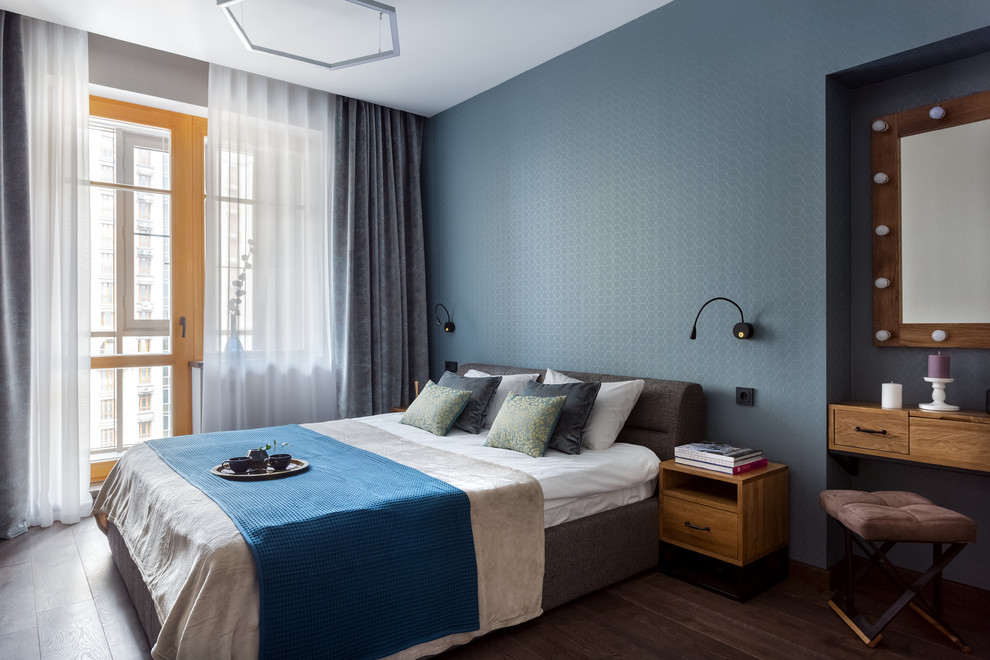 Réalisation d'une chambre parentale design de taille moyenne avec un mur bleu, un sol marron et parquet foncé.