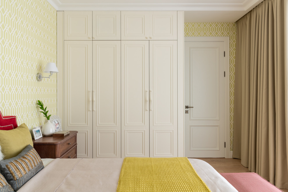 Modelo de dormitorio principal clásico de tamaño medio con paredes verdes, suelo de madera clara y suelo beige