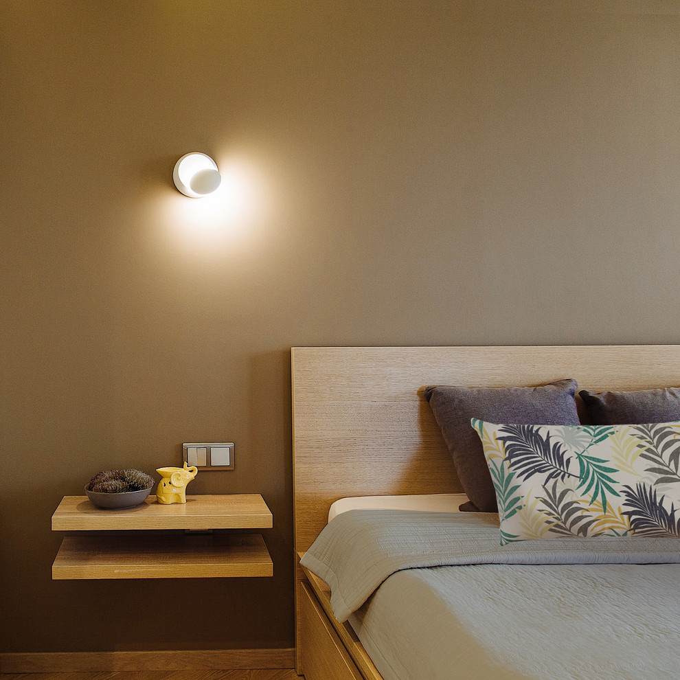 Modelo de dormitorio principal minimalista pequeño sin chimenea con paredes marrones, suelo de madera en tonos medios, marco de chimenea de ladrillo y suelo amarillo