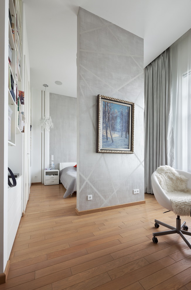 Immagine di una camera matrimoniale minimal con pareti grigie, pavimento in legno massello medio e pavimento marrone