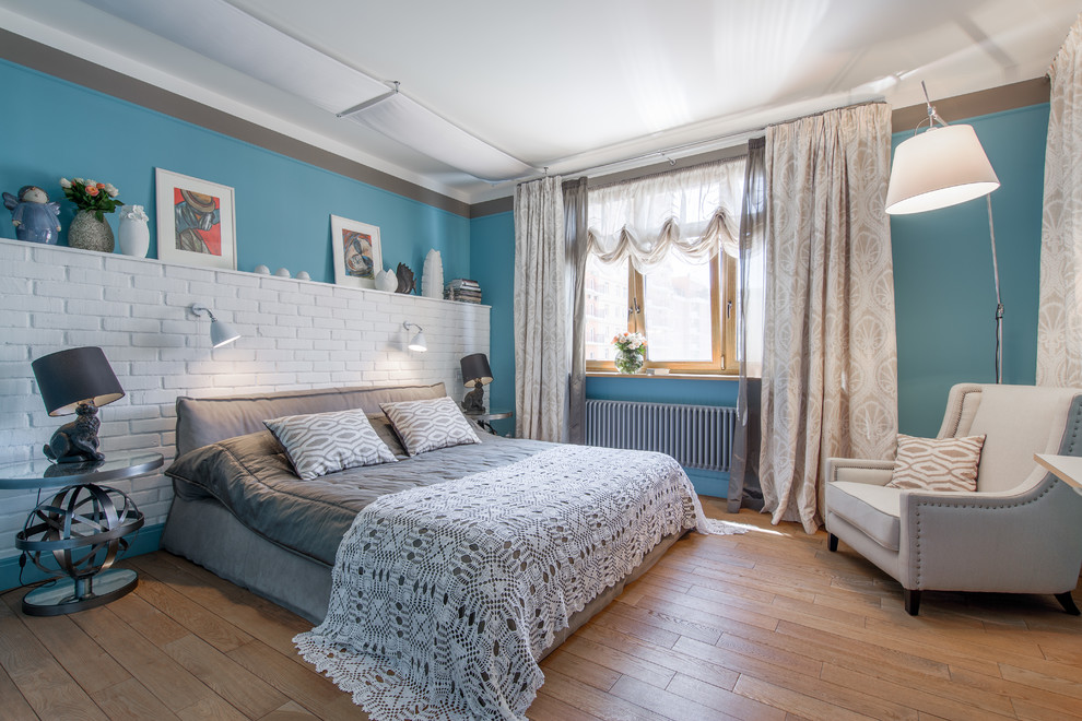 Ispirazione per una camera matrimoniale tradizionale con pareti blu e pavimento in legno massello medio