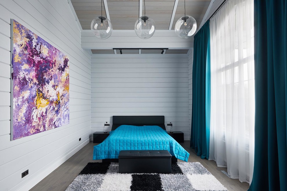Modelo de dormitorio principal actual grande con paredes blancas, suelo de madera en tonos medios y suelo marrón