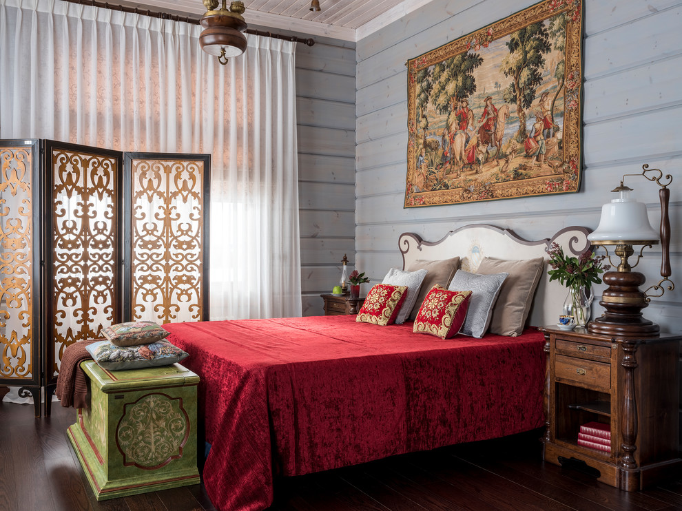 Immagine di una camera da letto bohémian con pareti blu, parquet scuro e pavimento marrone