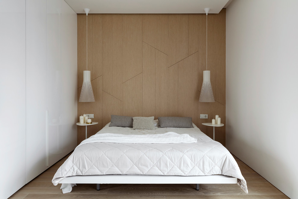 Immagine di una camera matrimoniale minimalista con pareti bianche, parquet chiaro e pavimento beige
