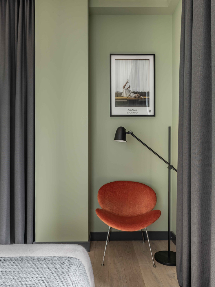 На фото: спальня в скандинавском стиле с зелеными стенами, паркетным полом среднего тона и серым полом