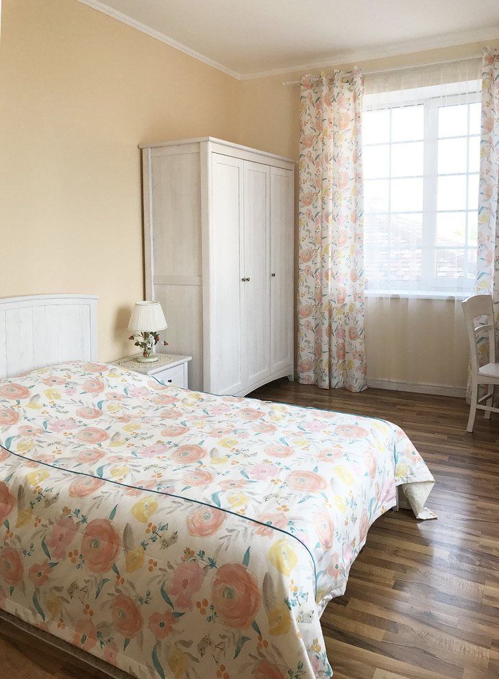 Идея дизайна: хозяйская спальня среднего размера в стиле кантри с бежевыми стенами, полом из ламината и коричневым полом без камина