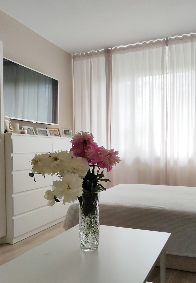 Kleines Modernes Hauptschlafzimmer ohne Kamin mit beiger Wandfarbe, Laminat und braunem Boden in Sankt Petersburg