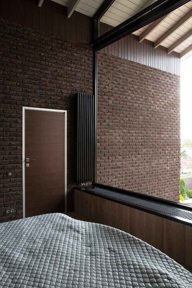 Foto de dormitorio principal contemporáneo extra grande sin chimenea con paredes marrones, suelo de madera clara y suelo marrón