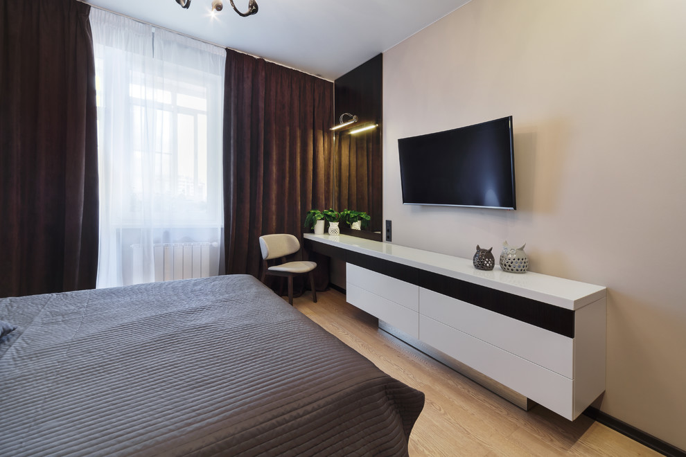Imagen de dormitorio principal actual de tamaño medio con paredes marrones, suelo de madera en tonos medios y suelo beige