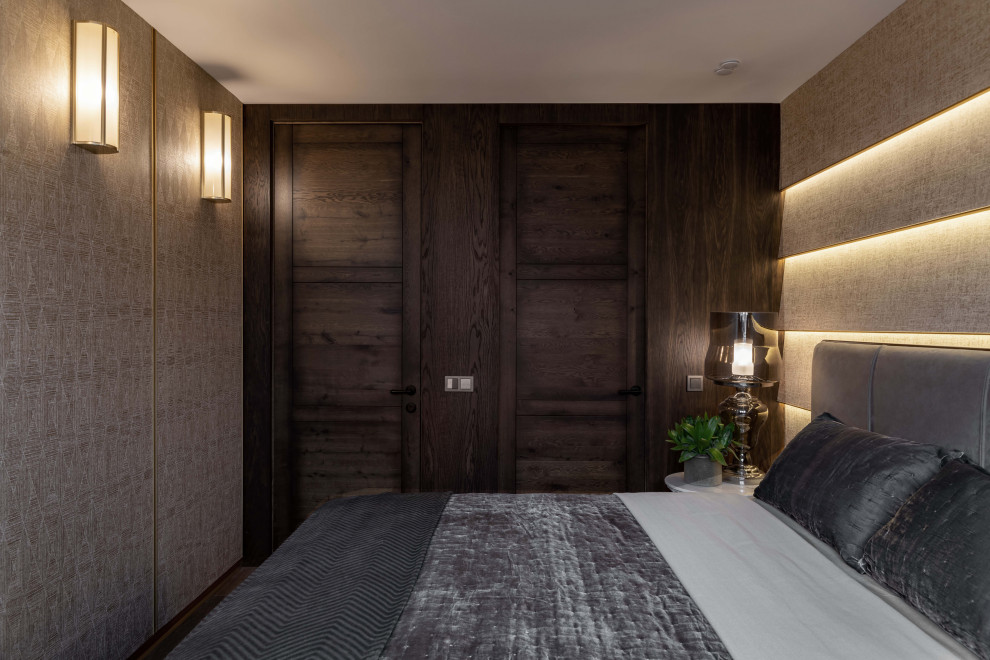 Kleines Klassisches Hauptschlafzimmer mit brauner Wandfarbe, dunklem Holzboden, braunem Boden und Tapetenwänden in Moskau