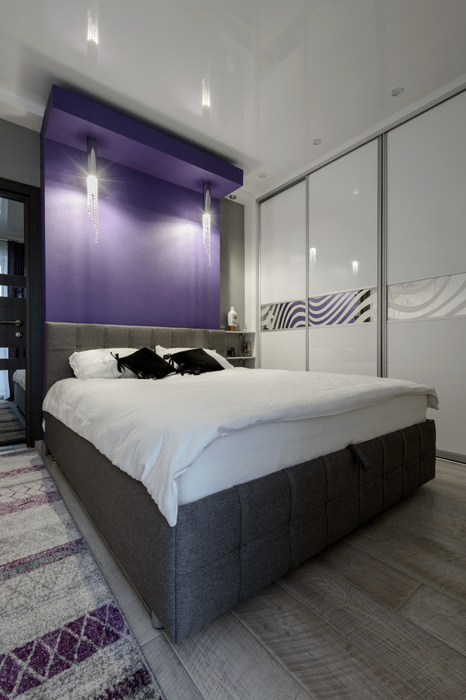 Réalisation d'une petite chambre parentale design avec un mur violet, sol en stratifié et un sol gris.