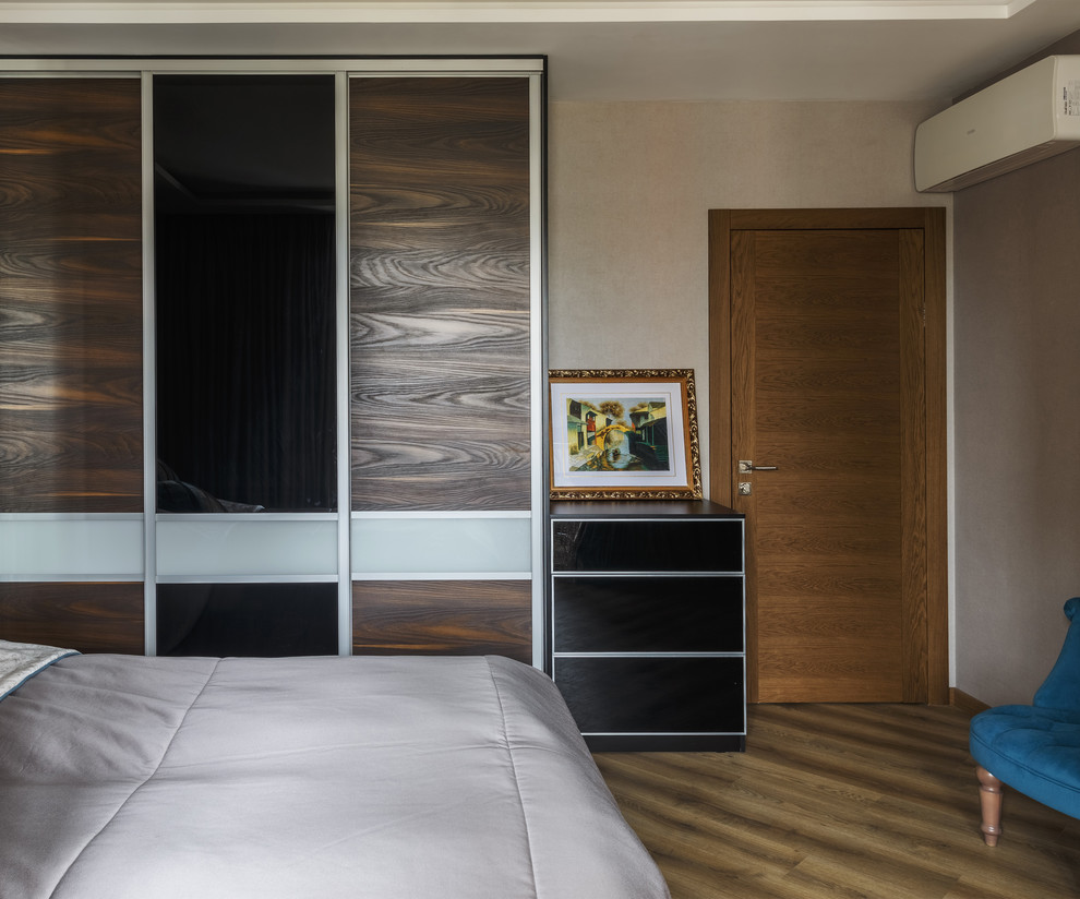 Modelo de dormitorio principal contemporáneo de tamaño medio sin chimenea con paredes beige, suelo vinílico y suelo beige