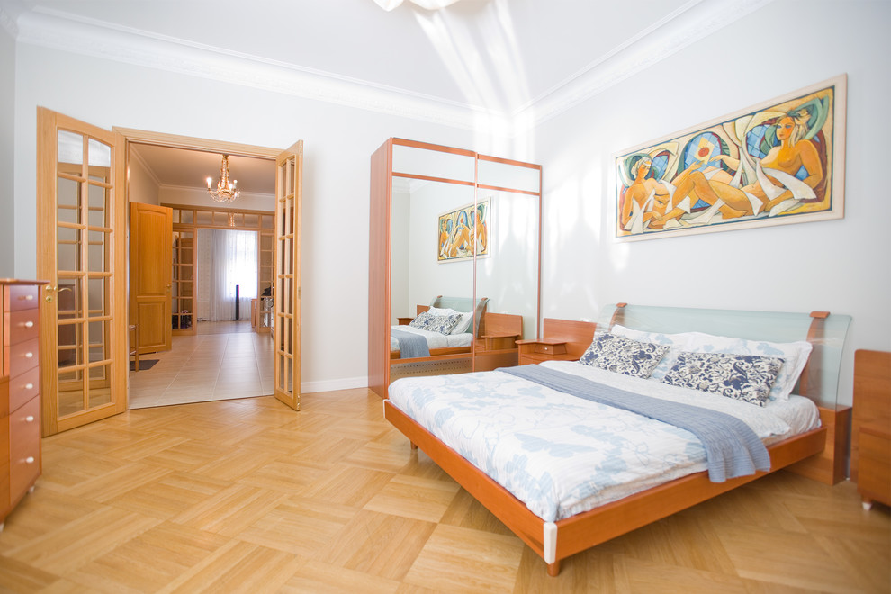 Свежая идея для дизайна: хозяйская спальня среднего размера в современном стиле с белыми стенами, желтым полом, светлым паркетным полом и кроватью в нише - отличное фото интерьера